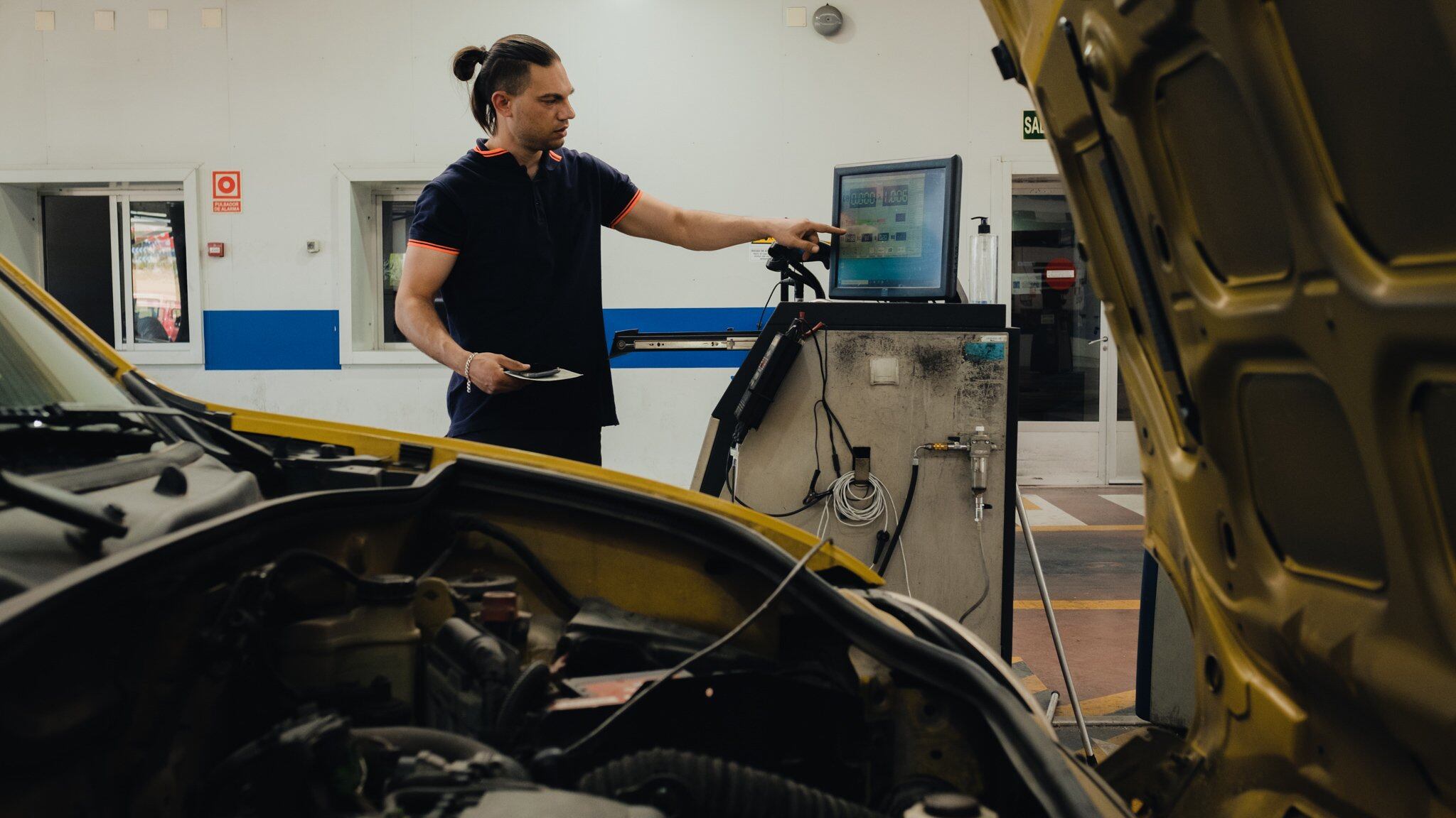 Mecánico realizando una inspección a un coche (AECA-ITV)