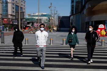 Personas con barbijo en una calle de Beijing (REUTERS/Thomas Peter)