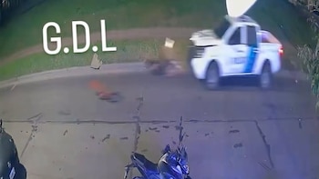 Una camioneta de policía blanca impacta a un hombre en una calle asfaltada, según el registro de una cámara de seguridad