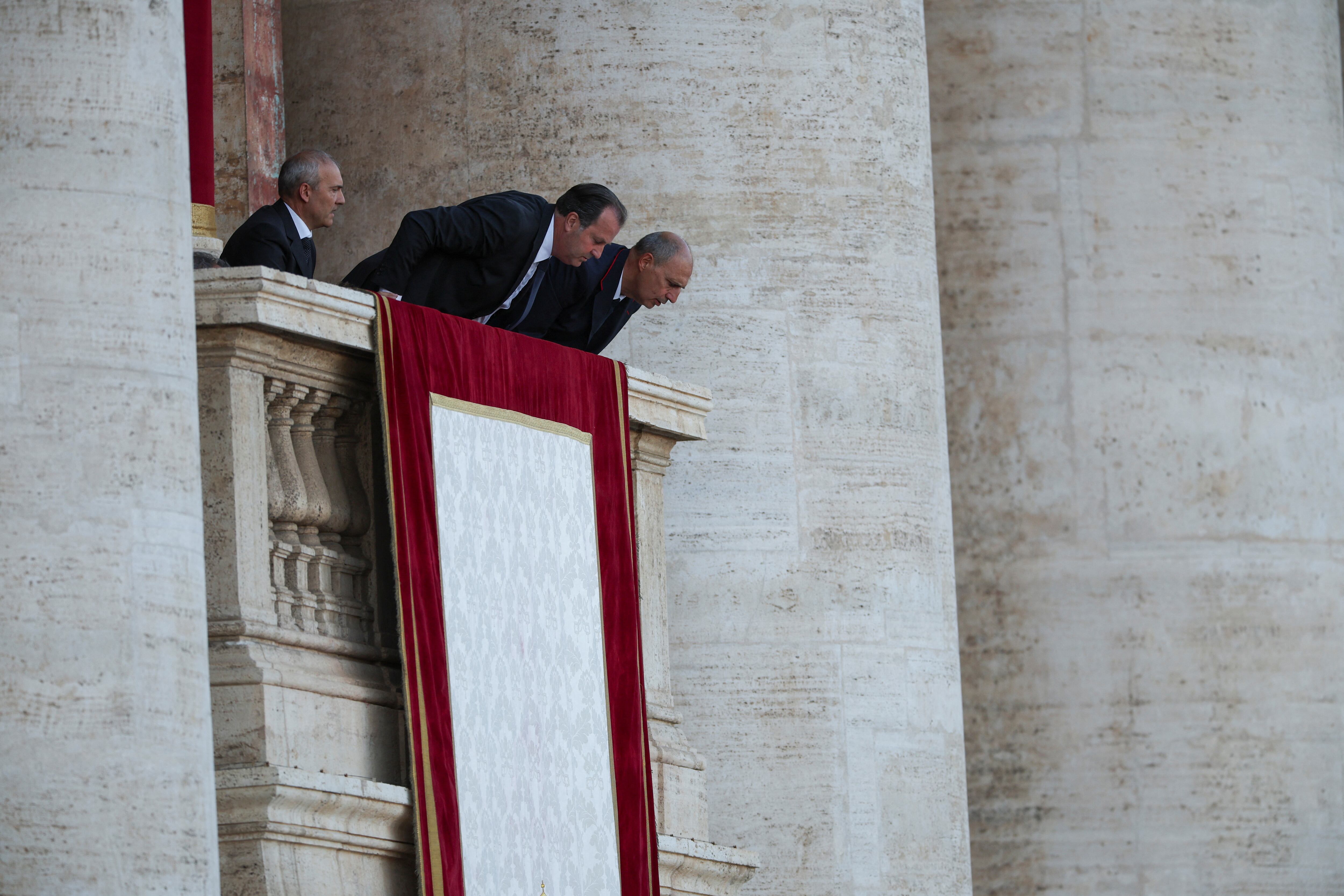 El personal del Vaticano despliega un tapiz papal, después de que el cónclave eligiera a un nuevo papa, en el Vaticano, el 8 de mayo de 2025