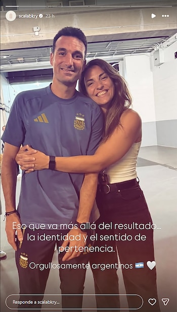 Un hombre y una mujer, ambos sonrientes, se abrazan. El hombre viste una camiseta azul con el escudo de la AFA. La mujer lleva una camiseta blanca
