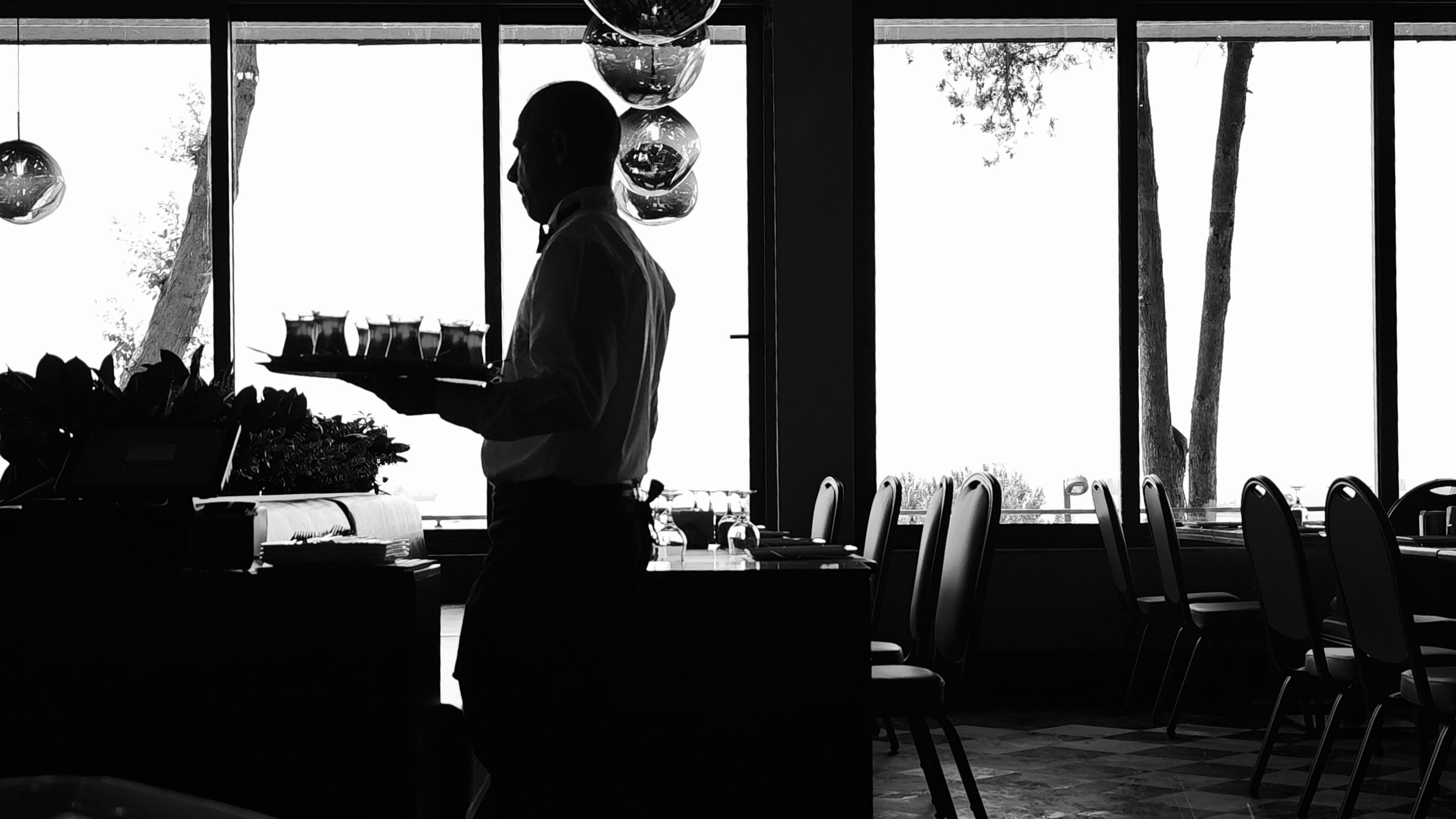 Imagen de archivo de un camarero sirviendo bebidas en un restaurante elegante (Pexels)