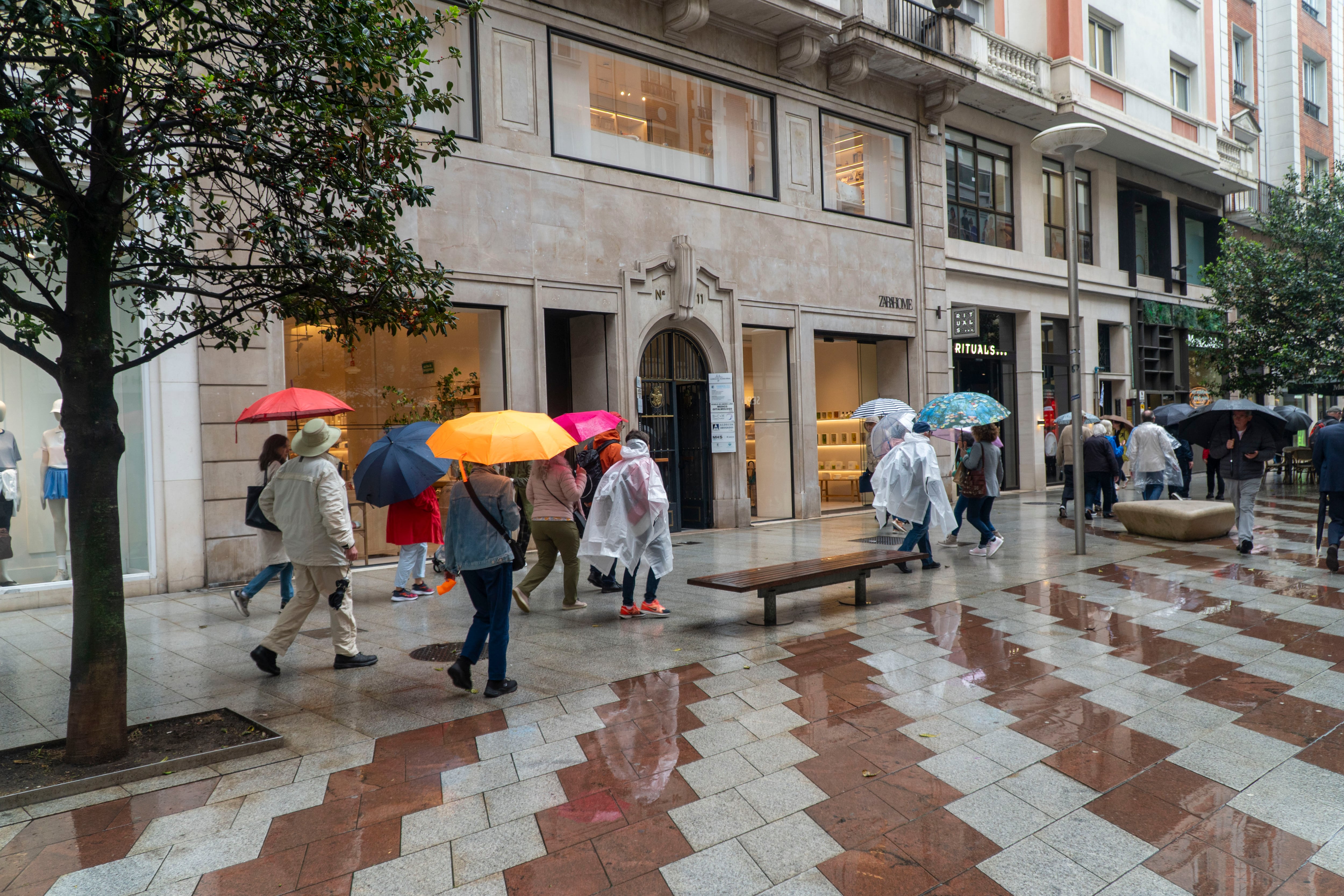 Varias personas se protegen de la lluvia caída este lunes en Santander. (EFE/Román G. Aguilera)
