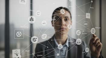 Uma mulher de terno interage com uma interface de usuário transparente, que mostra a imagem de uma rede com nós e linhas em seu rosto.