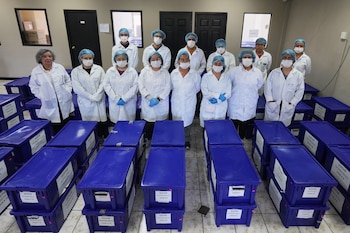 Archivistas posan para una foto grupal con cajas que contienen testimonios de víctimas del conflicto armado interno entre 1960 y 1996. Las cajas clasificadas por departamento reúnen relatos de crímenes vinculados a un conflicto que dejó alrededor de 200,000 muertos y cerca de 45,000 desaparecidos./ (Foto AP/Moisés Castillo)