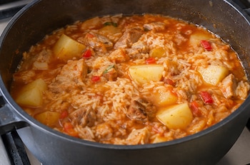 El secreto está en dorar bien la carne y cocinar el arroz con un caldo lleno de sabor - crédito VisualesIA