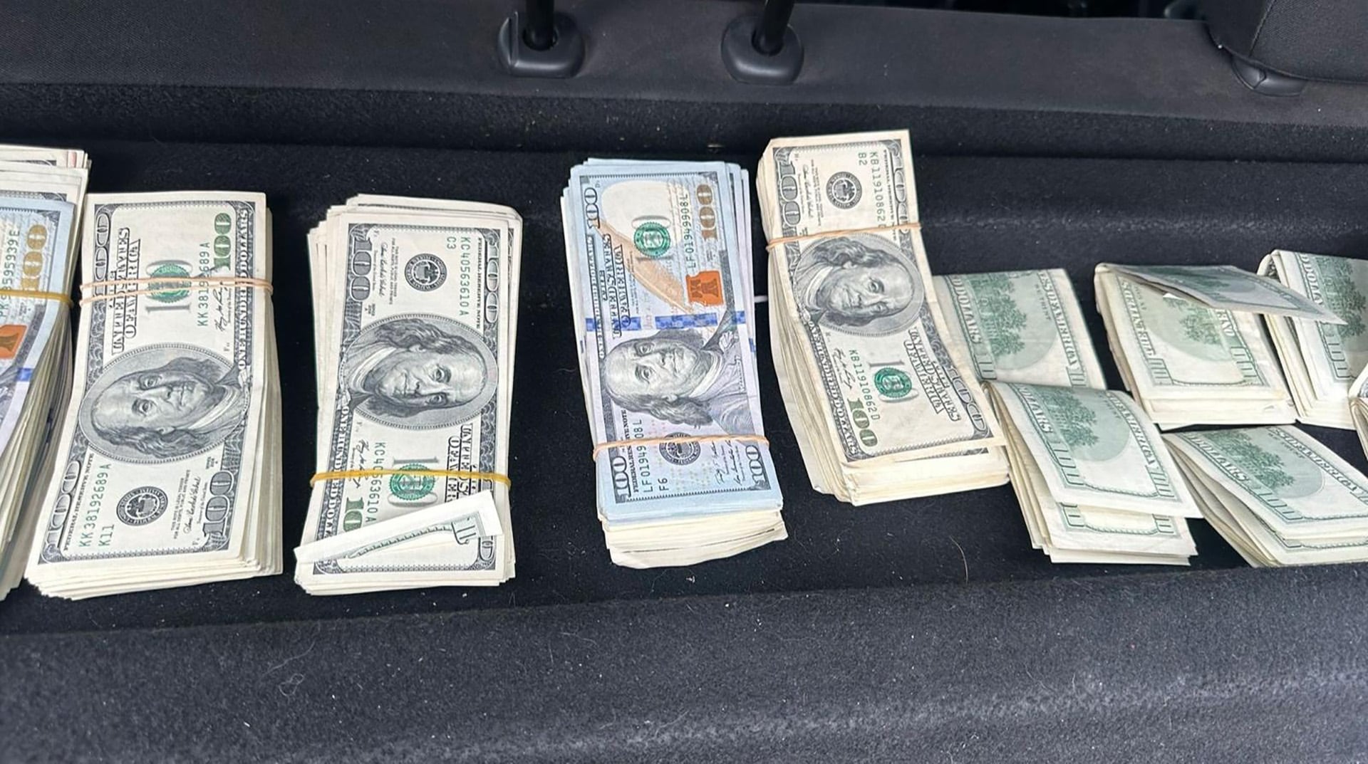Se observan varios fajos de billetes de cien dólares hallados en el auto del sospechoso