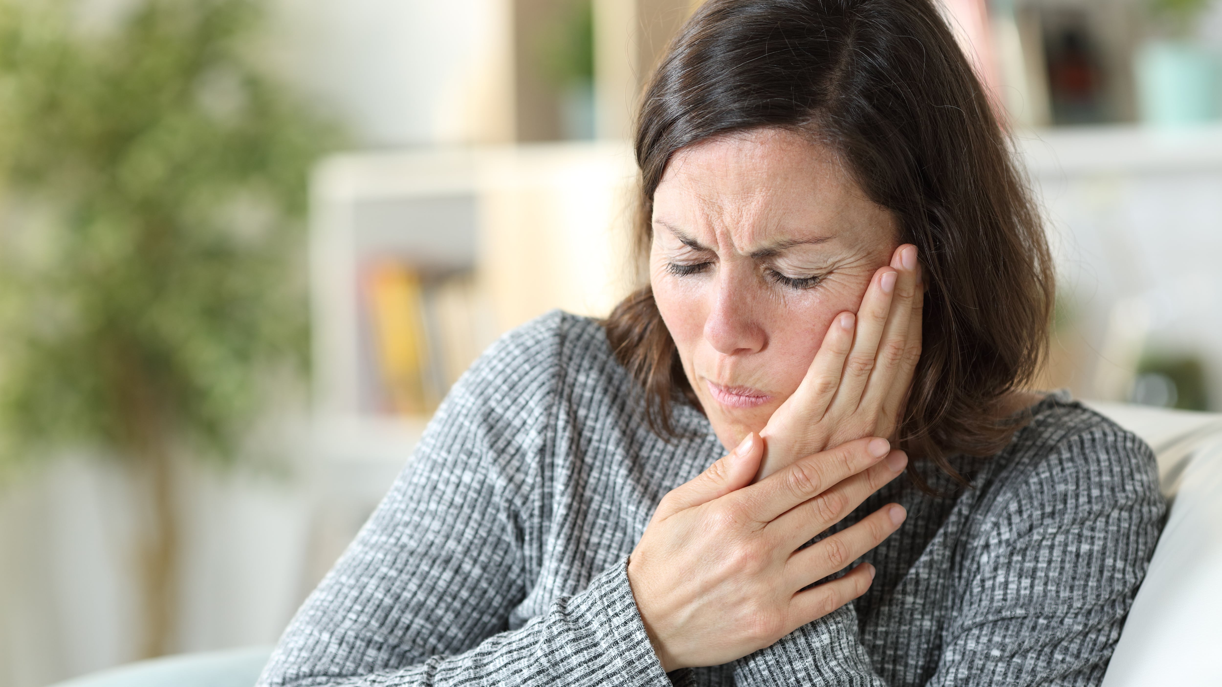 Una mujer con dolor de muelas (AdobeStock)