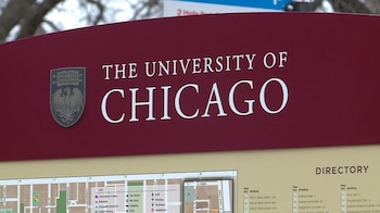 Un cartel rojo con el escudo y el nombre de la Universidad de Chicago en inglés, ubicado sobre un mapa de directorio