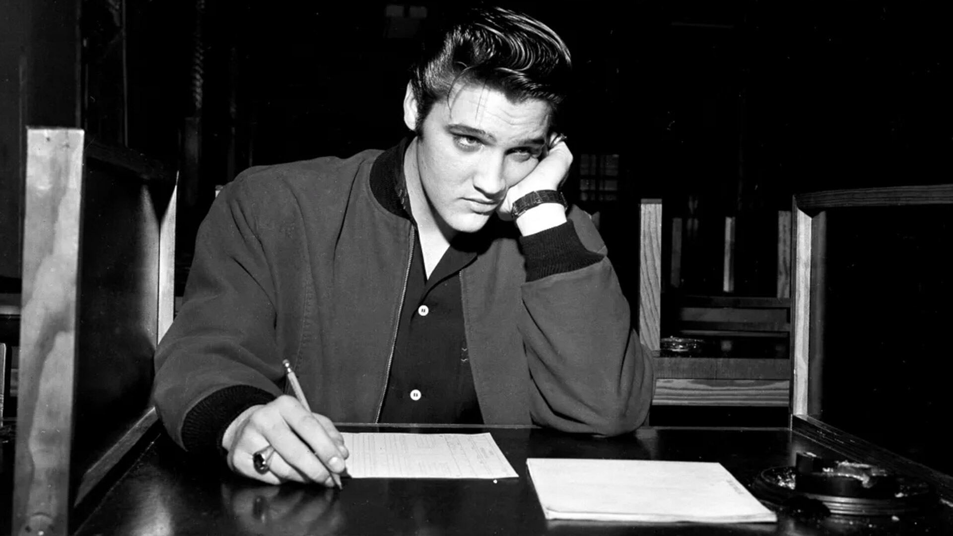 El cantante Elvis Presley, a los 21 años, mientras rendía su examen escrito previo al reclutamiento para el Ejército de los EE. UU. en Memphis, Tennessee, el 4 de enero de 1957 (Foto AP)
