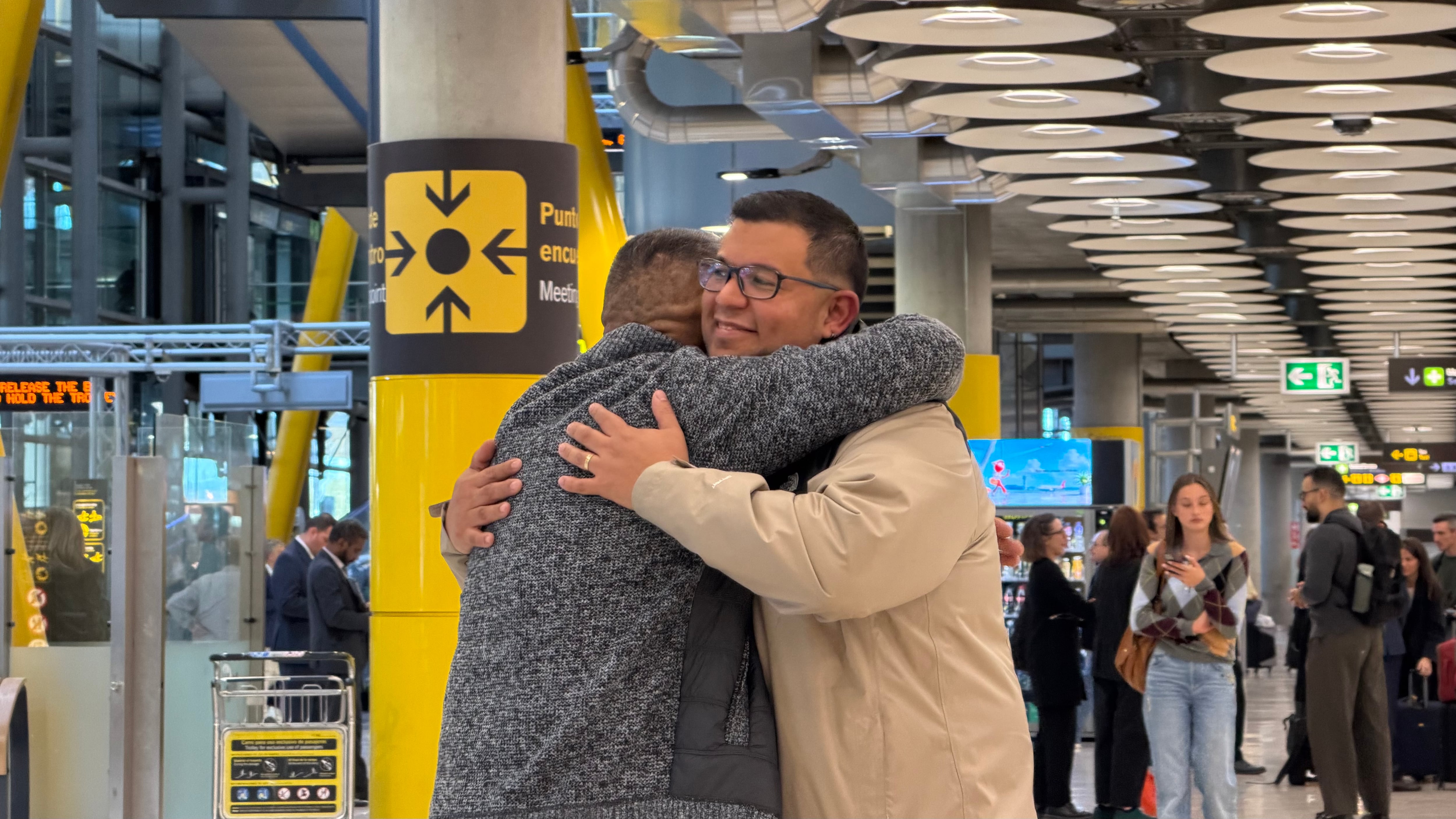 Padre e hijo se funden en un largo abrazo en Barajas tras toda una vida separados. (Infobae/Irene Herrero)