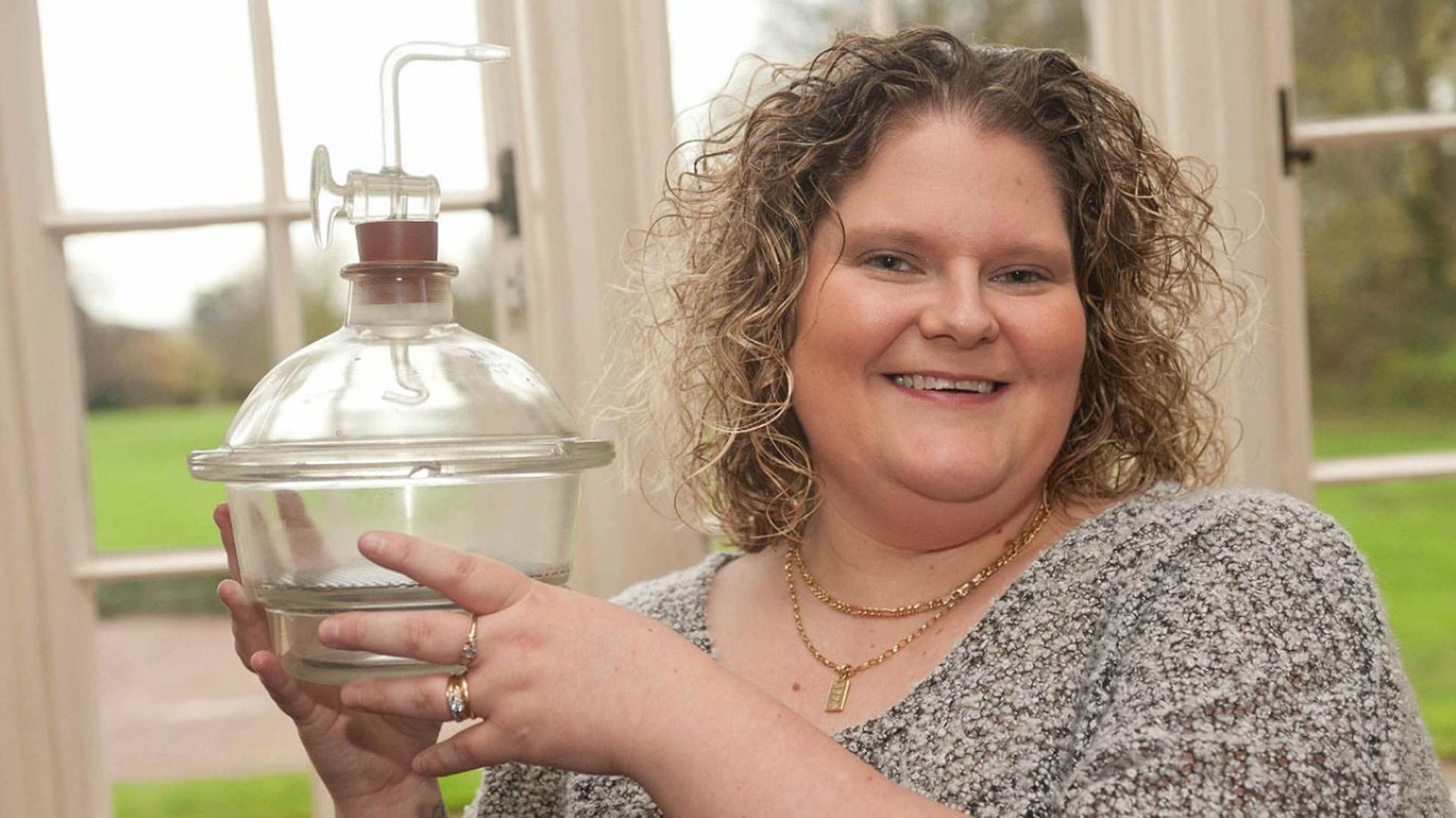 Louise Brown muestra el contenedor donde fue incubado su embrión después que el óvulo de la madre se fertilizara con el esperma del padre en un “Petri Dish”, o Placa de Petri.