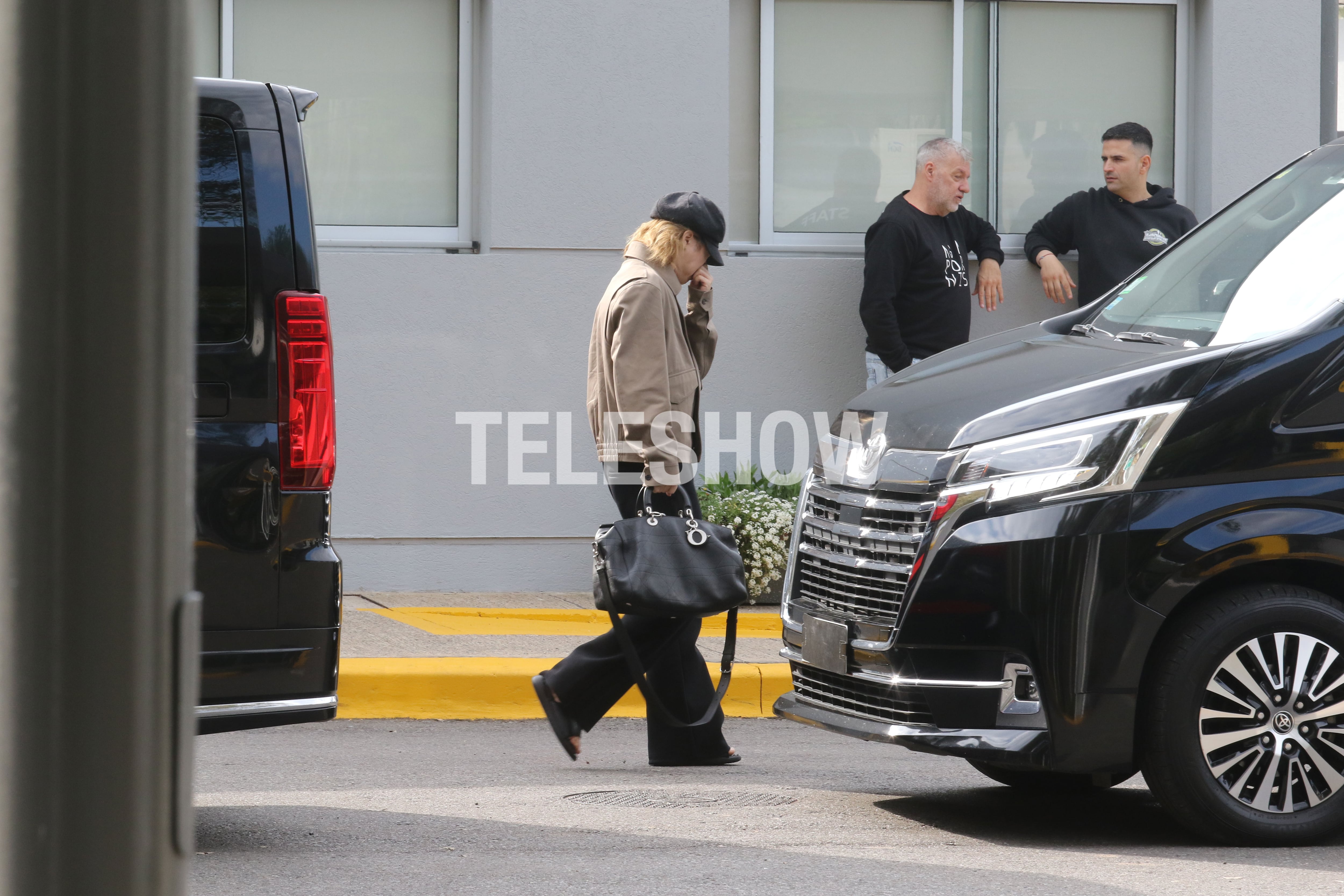 Jimin cruzó el estacionamiento con una campera beige y una gorra de cuero negra