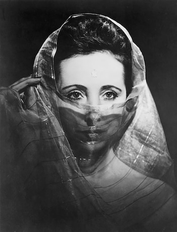 Retrato en blanco y negro de Anaïs Nin con un velo semitransparente que cubre su rostro, dejando a la vista sus ojos y parte de su frente