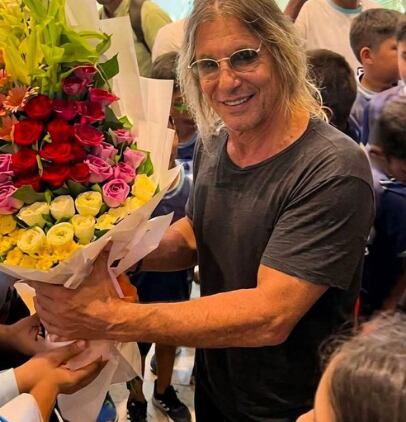 El exfutbolista argentino Claudio Caniggia recibe un ramo de flores de colores durante un encuentro en Bangladesh