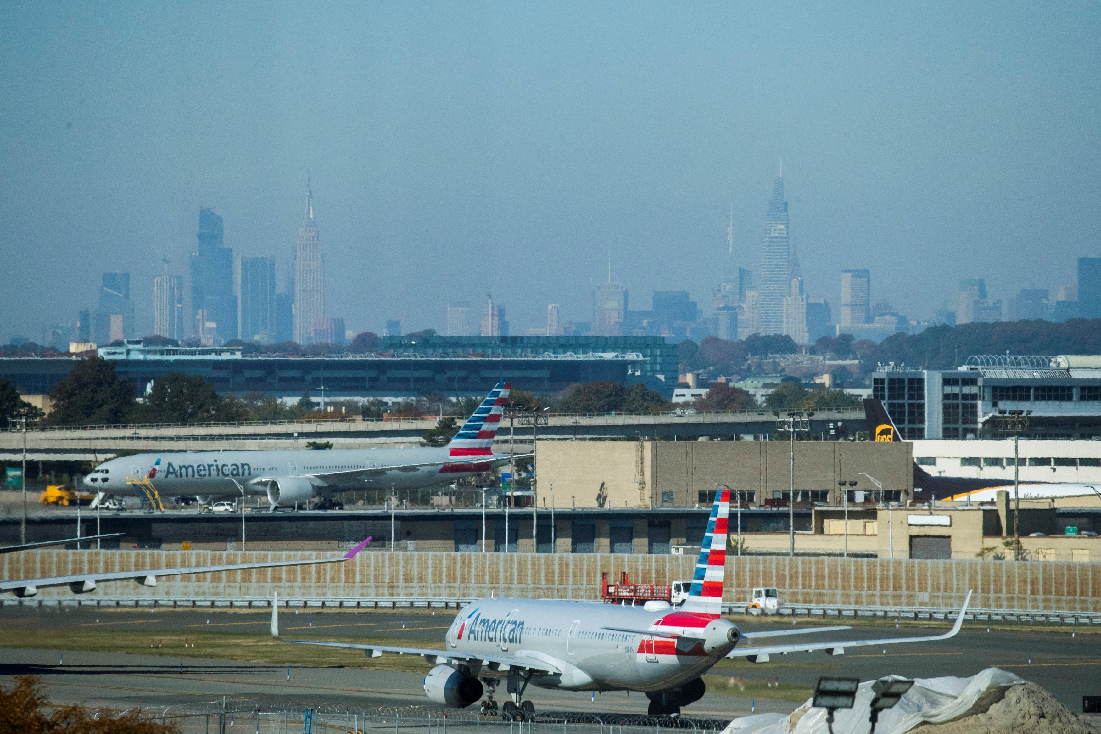 Aviones de American Airlines circulan por la pista mientras el horizonte de la ciudad de Nueva York se observa al fondo desde el Aeropuerto Internacional JFK en Nueva York (REUTERS/Eduardo Munoz/File Photo)