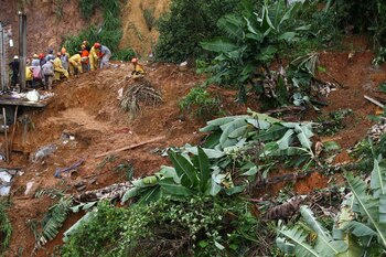 Bomberos y voluntarios buscan personas tras un deslizamiento de tierra después de fuertes lluvias en Franco da Rocha, San Pablo (REUTERS/Carla Carniel)