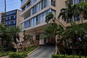 Edificio de apartamentos Coral Strand en Hawái con balcones, ventanas, palmeras, vegetación tropical y una rampa de acceso; se observa la numeración 2979