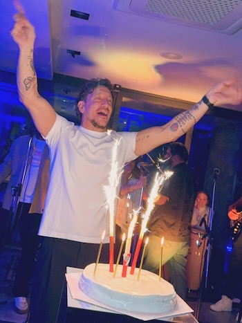 El cumpleaños de Nico Vázquez incluyó torta blanca con velas, bengalas encendidas, banda en vivo y copas de vino