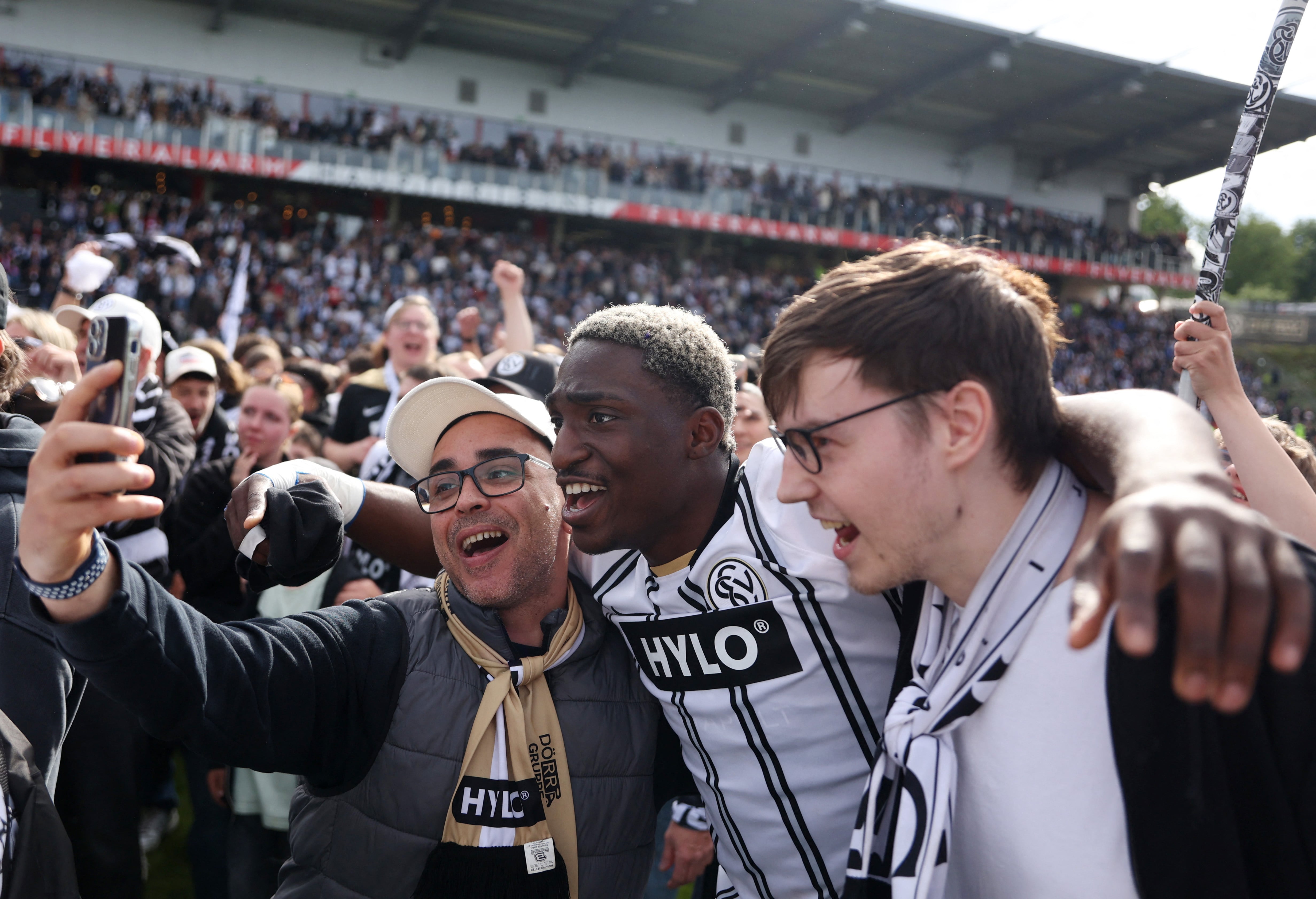 David Mokwa junto a varios fans del club. El Elversberg jugará la Bundesliga por primera vez en su historia en la temporada 2026-27 tras vencer 3-0 al Preussen Münster-crédito Thilo Schmuelgen/REUTERS