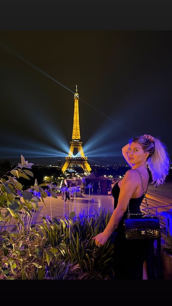 Wanda Nara posó frente a la Torre Eiffel iluminada con un vestido negro y una cartera Chanel, en una de las imágenes que publicó durante su estadía en París