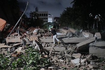 Un hombre salta sobre un edificio derrumbado tras un terremoto en Caracas, Venezuela, el miércoles 24 de junio de 2026. (AP Foto/Adrián Naranjo)