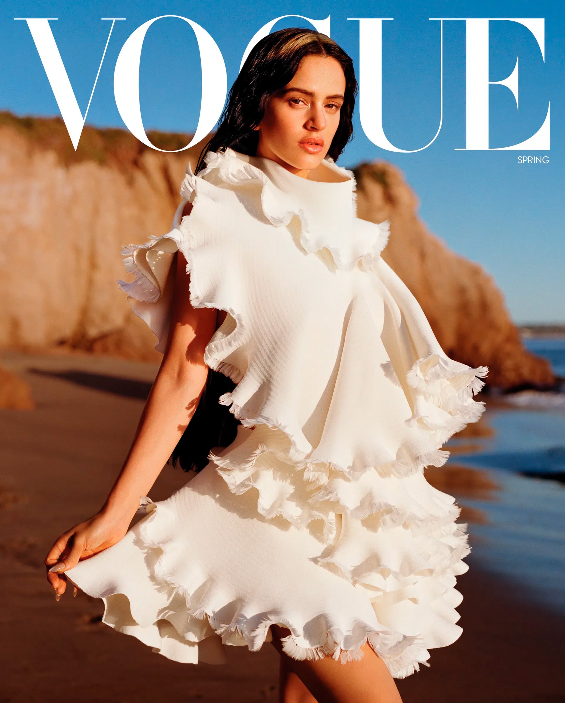 La superestrella española Rosalía protagoniza la portada de Vogue, luciendo un espectacular vestido blanco con volantes en un idílico escenario playero al atardecer.