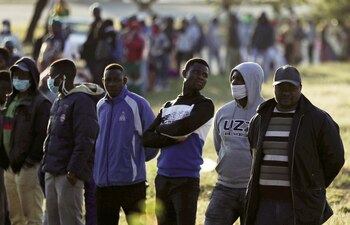 Comerciantes informales hacen cola mientras