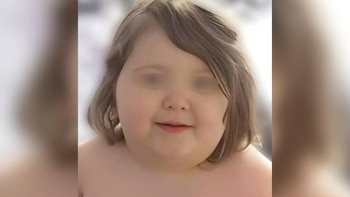 Primer plano de un niño con cabello castaño claro, ojos pixelados, que sonríe ligeramente y tiene los hombros descubiertos