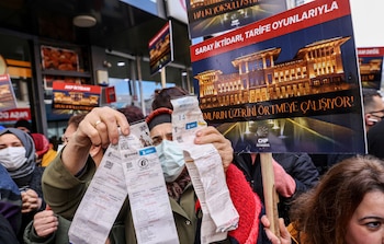 Una mujer muestra sus facturas
