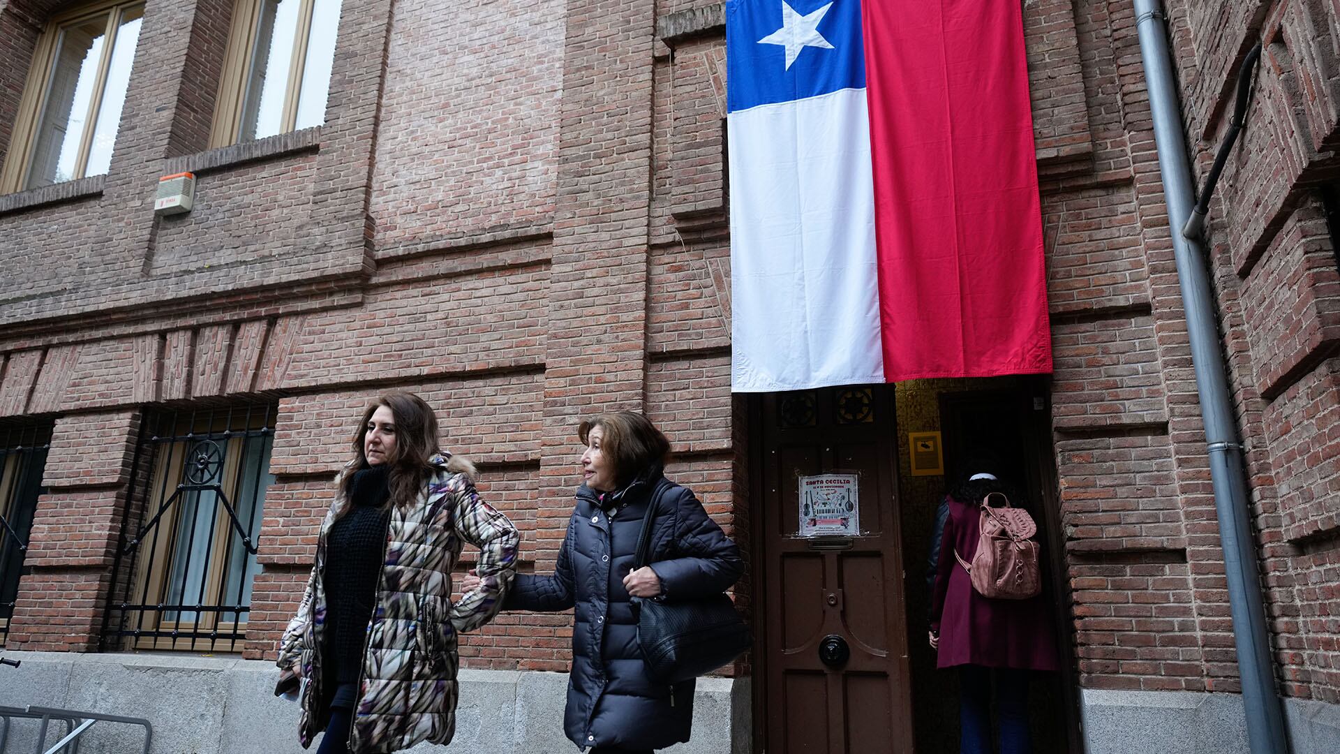 Dos mujeres salen de un colegio electoral instalado en Madrid, este domingo (EFE/Borja Sánchez-Trillo)