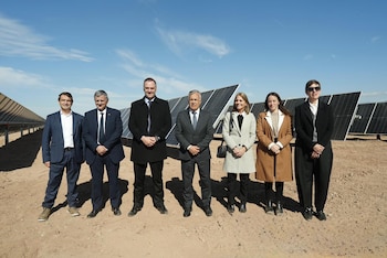 Sete pessoas, incluindo Manuel Adorni, Alfredo Cornejo e Horacio Marín, diante de um painel solar num campo seco, sob um céu azul.