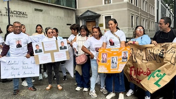 Un grupo de personas protesta en la calle, sosteniendo pancartas con fotos y textos, y una manta blanca con la frase 'Libertad Para todos Los Presos Políticos Ley de Amnistía'