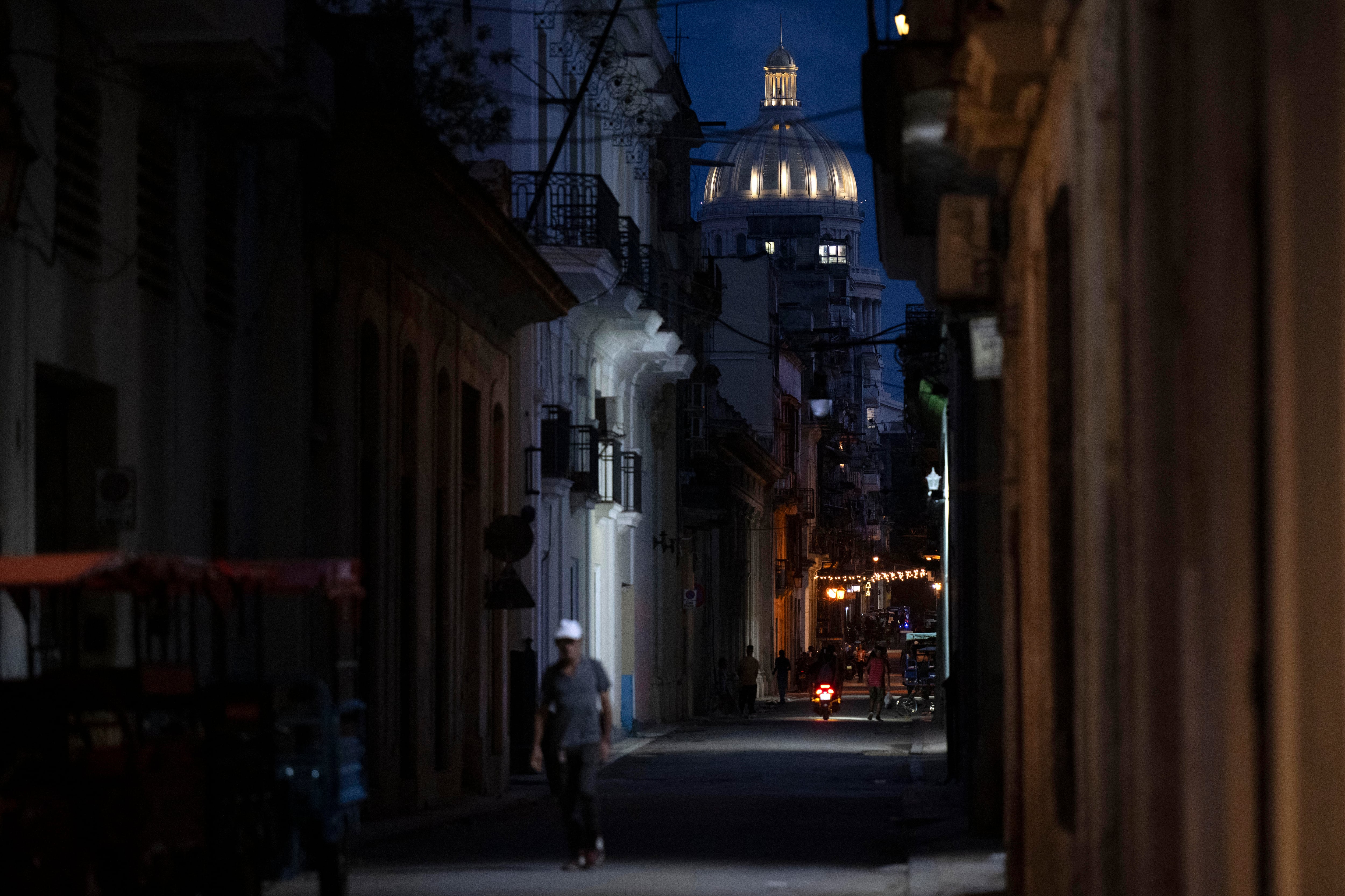 A man walks through a place traditionally visited by tourists in Old Havana that appears empty due to a lack of visitors in Havana on June 9, 2026. Once synonymous with carefree revelry, Havana is fading away amid power cuts, an exodus and deep uncertainty about its future. There are so few cars driving along the Malecn, the capitals iconic seafront promenade that once bustled with activity, that it is possible to cross it without looking. (Photo by Pablo PORCIUNCULA / AFP)