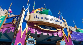 Entrada colorida a la atracción 'it's a small world' con cartel principal, señal de 'stand-by entrance' y reloj de tiempo de espera de 40 minutos