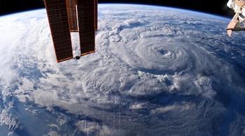 Tierra, atmósfera, nubes, huracán, ojo del huracán, paneles solares, estructura de nave espacial, espacio exterior.