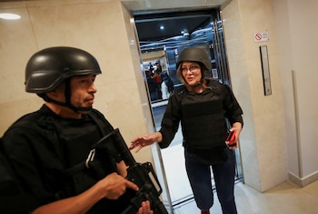 Un agente de policía llega con Verónica Sarauz, viuda del excandidato presidencial ecuatoriano Fernando Villavicencio, un crítico declarado de la corrupción y el crimen organizado, para asistir a una conferencia de prensa en un hotel, luego de que Villavicencio fuera asesinado durante un acto de campaña, en Quito, Ecuador, el 12 de agosto de 2023. REUTERS/Henry Romero