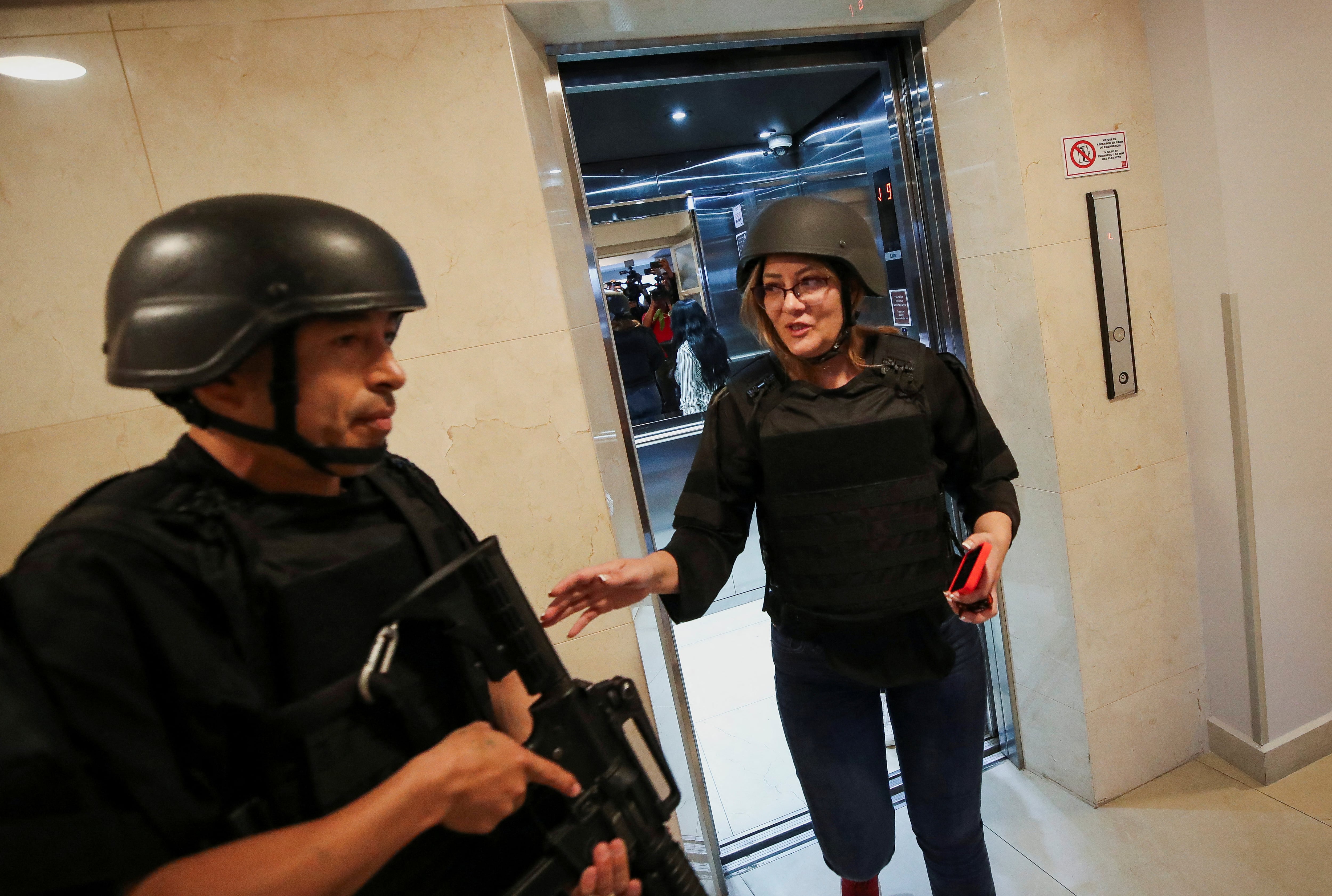 Un agente de policía llega con Verónica Sarauz, viuda del excandidato presidencial ecuatoriano Fernando Villavicencio, un crítico declarado de la corrupción y el crimen organizado, para asistir a una conferencia de prensa en un hotel, luego de que Villavicencio fuera asesinado durante un acto de campaña, en Quito, Ecuador, el 12 de agosto de 2023. REUTERS/Henry Romero