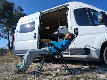 Javier Flores frente a la furgoneta que ha convertido en su casa en los últimos dos años y medio. (Cedida a Infobae)