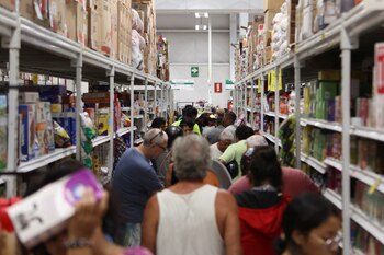 Personas hacen fila para pagar