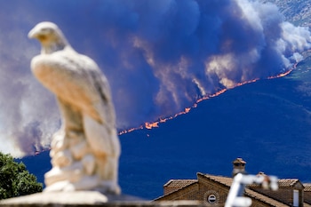 Medios aéreos trabajan en las labores de extinción del incendio entre las localidades abulenses de Burgohondo y Navaluenga. (EFE/Raúl Sanchidrián)