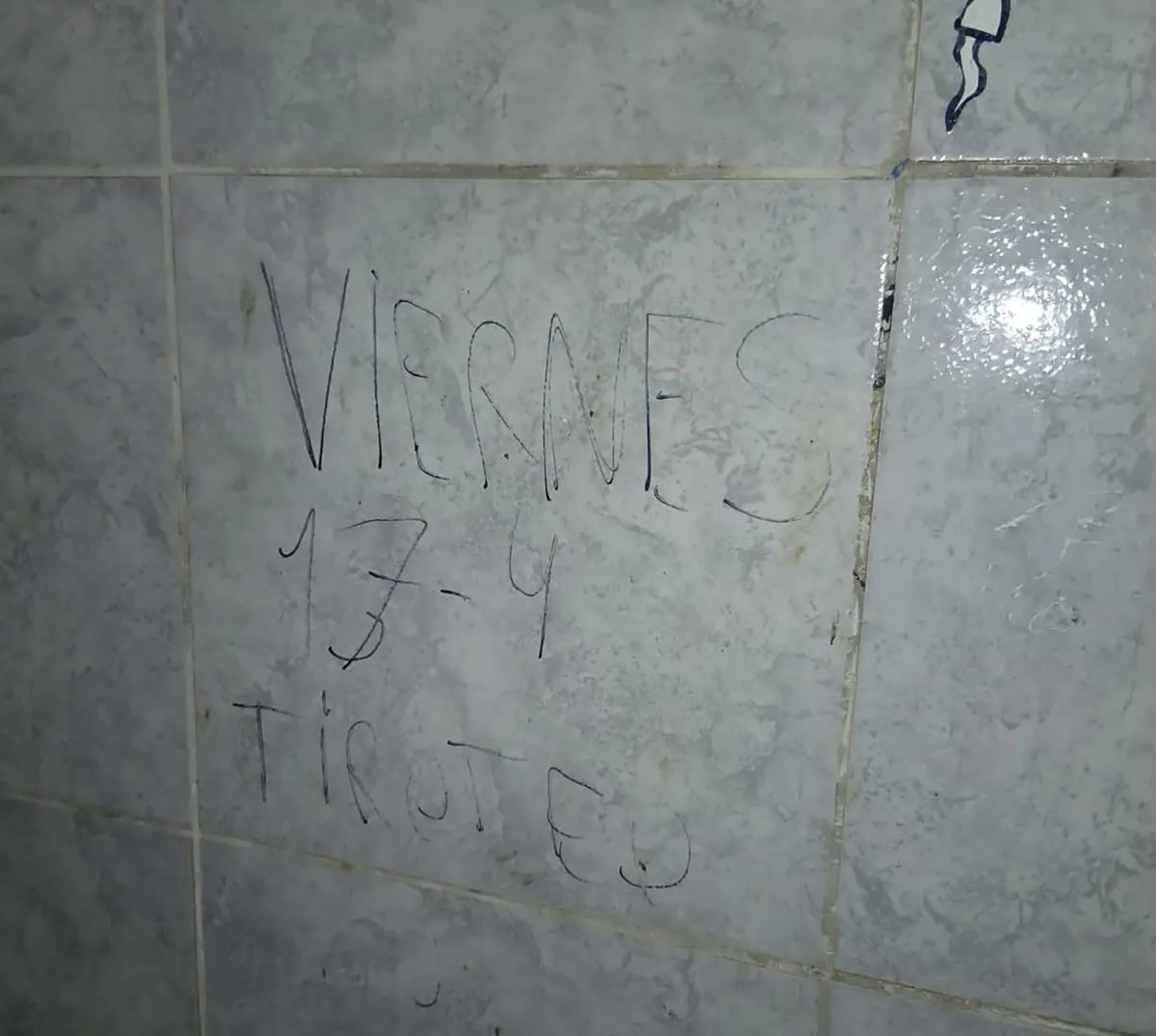 Una amenaza de tiroteo escrita sobre una pared de azulejos