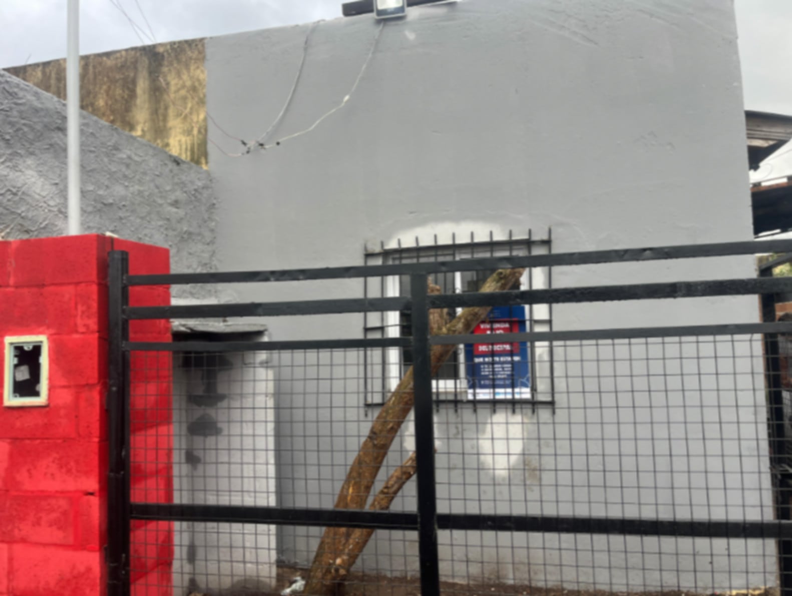 La vivienda en Moreno, presuntamente vinculada a casos de usurpación por una banda, exhibe un cartel de 'Vivienda Ilegal' en su ventana con barrotes (Policía Bonaerense)
