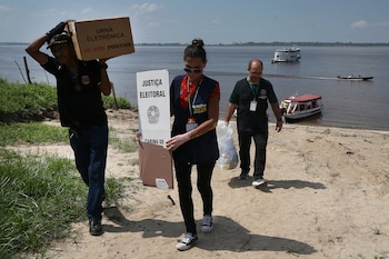 Trabajadores electorales con urnas para votos en Costa do Jatuarana, en el estado de Amazonas, Brasil, el 3 de octubre del 2026. (AP foto/Edmar Barros)