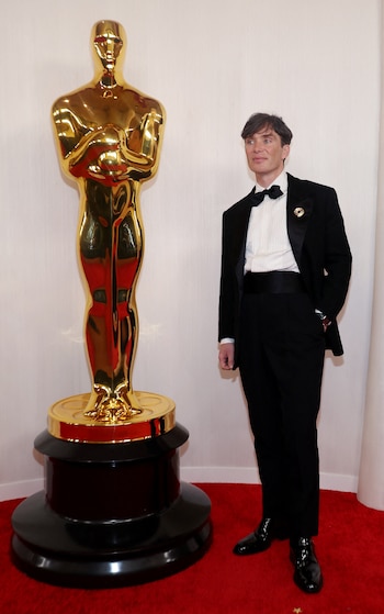 El esmoquin negro con moño suma un pin dorado como único detalle visible, con fajín negro, camisa con textura y zapatos de charol (REUTERS/Aude Guerrucci)