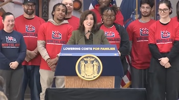Kathy Hochul habla tras un podio con el sello de Nueva York frente a personas con camisetas del Northland Workforce Training Center
