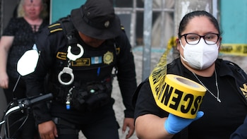 na integrante del Ministerio Público (MP) de Guatemala pone una cinta de seguridad en los alrededores de una cevichería, donde ocurrió un tiroteo que dejó a 5 personas asesinadas, este lunes en Ciudad de Guatemala (Guatemala). EFE/ Alex Cruz