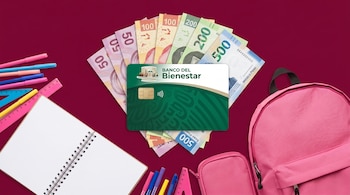 Composición de una tarjeta Banco del Bienestar, billetes de pesos mexicanos, mochila rosa, estuche, libreta, reglas y marcadores sobre fondo burdeos.