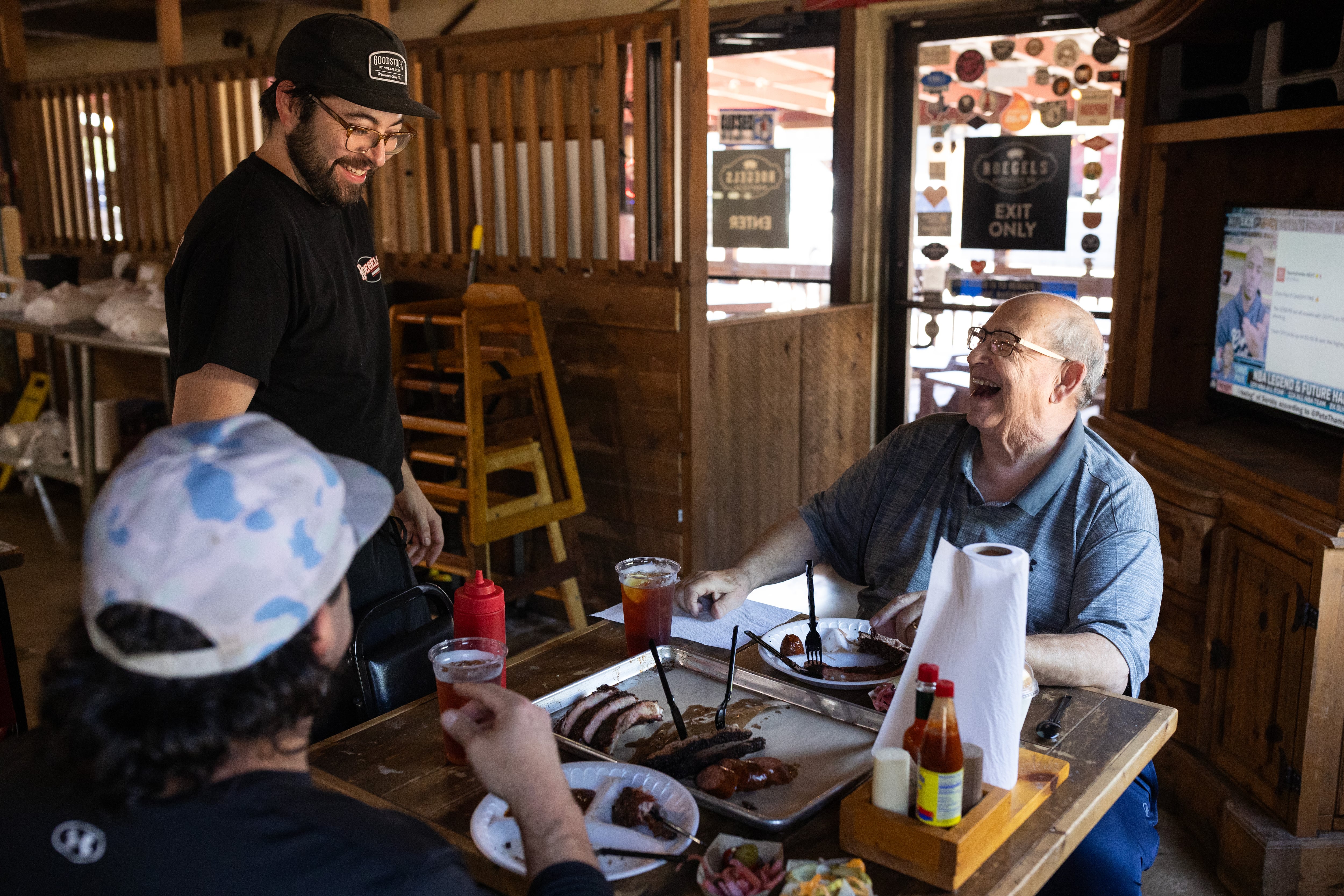 Alfredo Tapia saluda a Scott Urice (derecha) y a Daniel Valles a la hora del almuerzo en Roegels Barbecue Co (Antranik Tavitian/For The Washington Post)