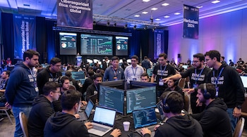Un grupo de personas trabaja en laptops y pantallas de computadora en un evento de ciberseguridad con banners de 'Hackathon 2024' y 'Ciberseguridad Ética'.